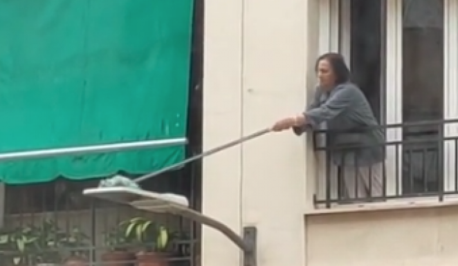 Una mujer de Granada sorprende limpiando la farola de su calle